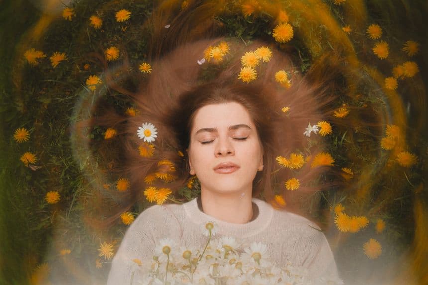 Femme allongée paisblement sur un sol fleuri, avec des ondes émanant de sa tête